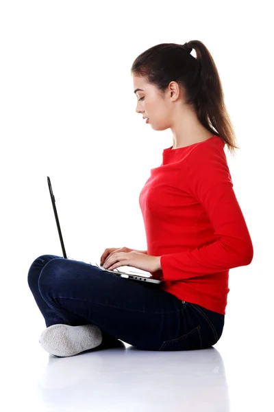Side view woman sitting cross-legged with laptop Stock Photo