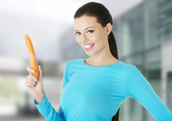 Mujer sosteniendo una zanahoria — Foto de Stock