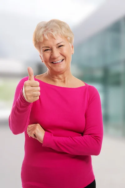 Oude vrouw het dragen van roze shirt, weergegeven: Ok. — Stockfoto