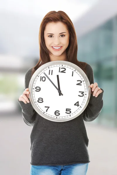 Mujer feliz sosteniendo reloj de oficina — Foto de Stock