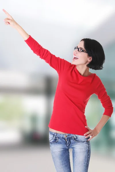 Happy young woman pointing on copy space — Stock Photo, Image