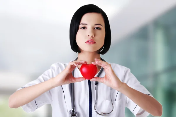 Médica feminina segurando modelo de coração — Fotografia de Stock