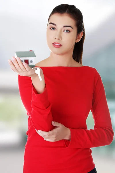 Mujer sosteniendo un modelo de casa — Foto de Stock