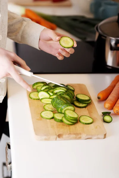 Woman slicing cucumber — Stock Photo, Image