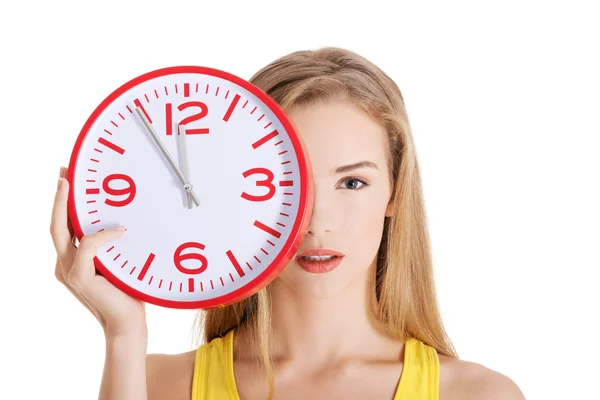 Atractiva joven mujer sosteniendo un reloj . —  Fotos de Stock