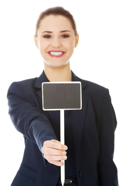 Glimlachende zakenvrouw houden kleine leeg bord — Stockfoto