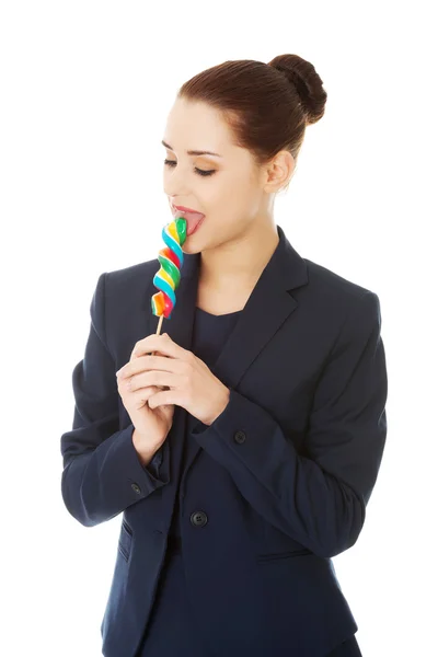 Young businesswoman licking a lolipop — Stock Photo, Image