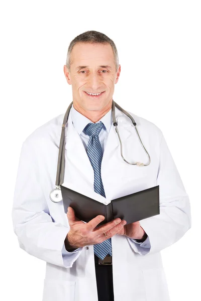 Mature male doctor holding notebook — Stock Photo, Image