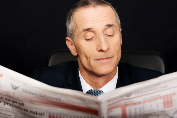 Empresario leyendo un periódico en la oficina — Foto de Stock