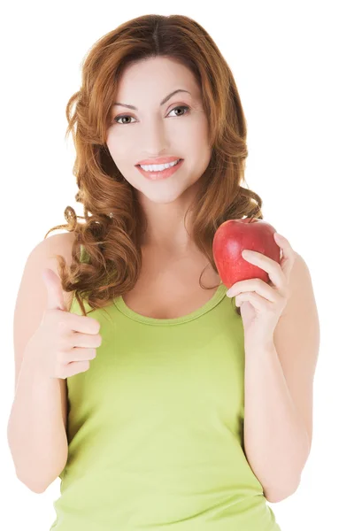 Mujer feliz sosteniendo una manzana con el pulgar hacia arriba — Foto de Stock