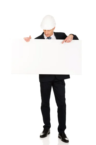 Uomo d'affari con cappello rigido con banner vuoto — Foto Stock