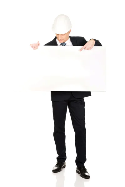 Businessman with hard hat holding empty banner — Stock Photo, Image