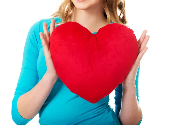 Mujer con almohada en forma de corazón — Foto de Stock