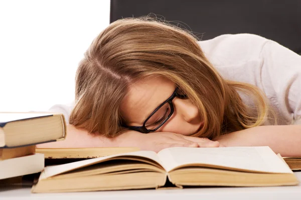 Mujer cansada con una pila de libros Imagen de stock