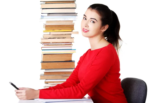 Femme assise avec une pile de livres — Photo