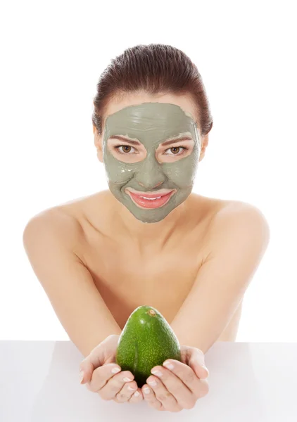 Beautiful spa woman in facial mask and avocado — Stock Photo, Image