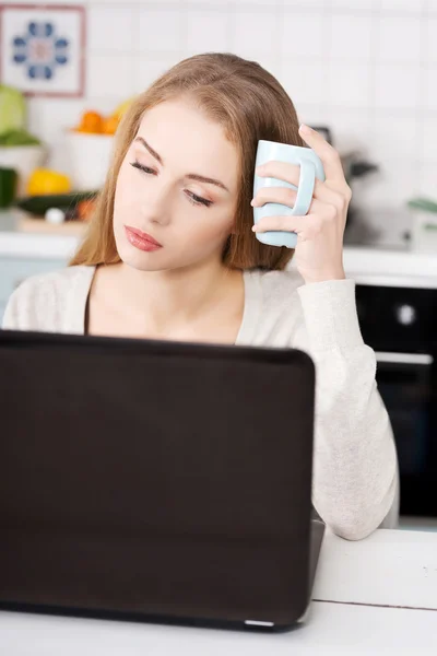 Mladá žena doma pomocí přenosného počítače — Stock fotografie