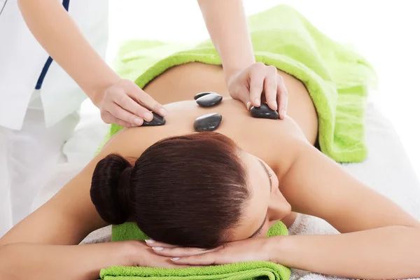 Chica en una terapia de piedra, masaje de piedra caliente — Foto de Stock