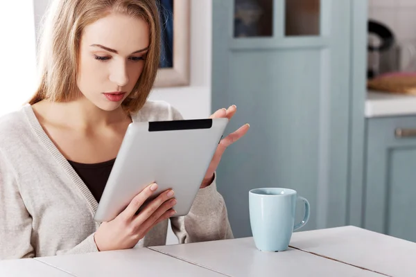 Mujer joven usando una tableta en casa — Foto de Stock