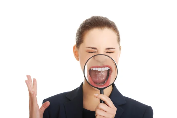 Business woman looking into a magnifying glass — Stock Photo, Image