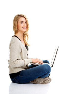 Gülümseyen kadın dizüstü bilgisayar kullanıyor.