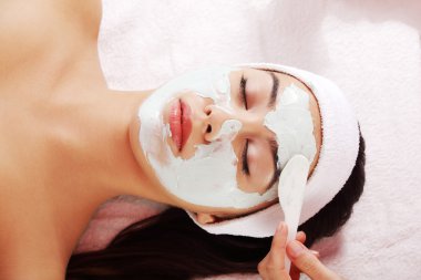 Relaxed woman with a nourishing face mask clipart