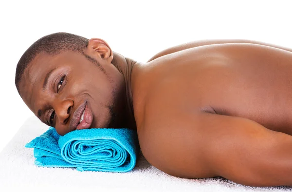 Homem deitado em uma mesa de massagem — Fotografia de Stock