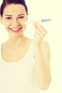 Hamilelik testi ile mutlu gülümseyen kadın.