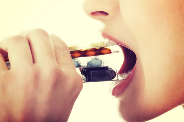 Mujer joven comiendo pastillas . — Foto de Stock