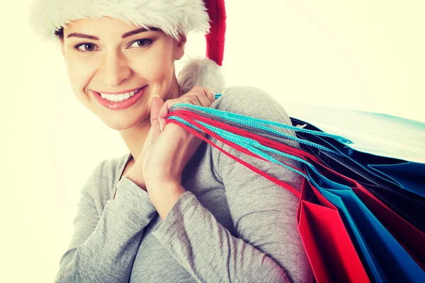 Mulher bonita em chapéu de Santa com sacos de compras . — Fotografia de Stock