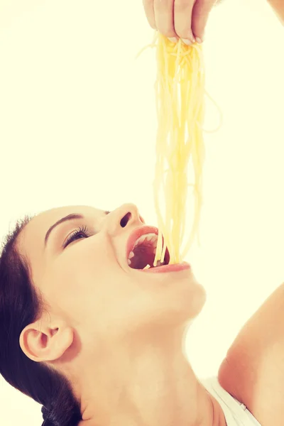 Junge schöne Frau isst rohe Pasta. — Stockfoto