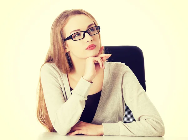 Beautiful thoughtful woman in eyeglasses sitting. — Stock Photo, Image