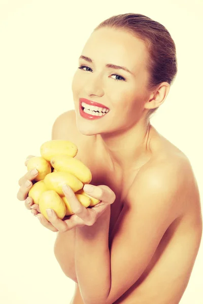 Beautiful woman holding raw potatoes in hands. — Stock Photo, Image