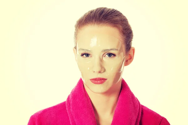 분홍색 목욕 가운 데 얼굴 마스크에 여자. — 스톡 사진