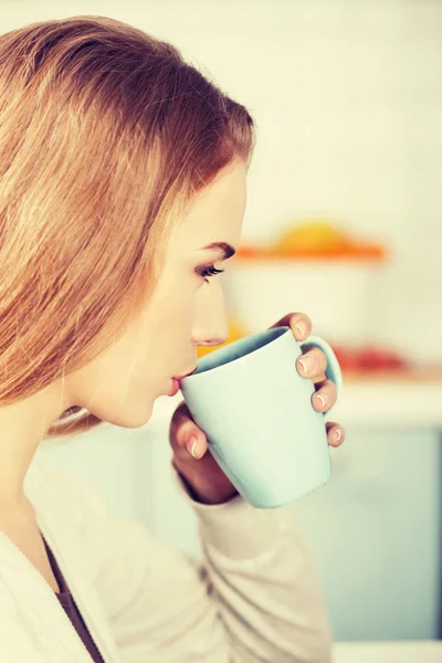 Beautiful caucasian woman is drinking hot drink. — Stock Photo, Image