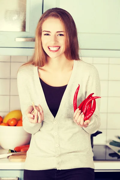 Vrouw houdt chili peppers en knoflook. — Stockfoto