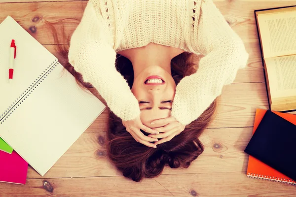 Beautiful woman lying on the floor with books. — Stock Photo, Image