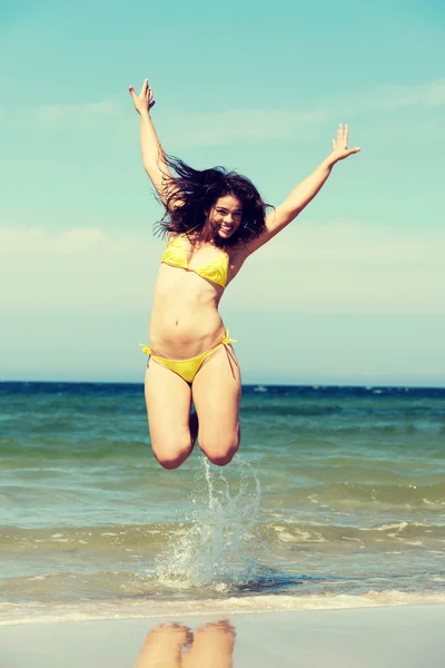 Beautiful woman in swimsuit jumping over seaside. Royalty Free Stock Photos