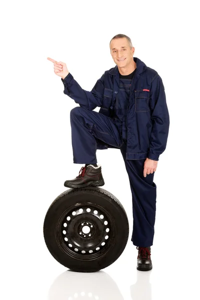 Reparador con pierna en un neumático —  Fotos de Stock