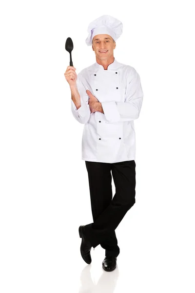 Шеф-повар держит черную пластиковую ложку — стоковое фото