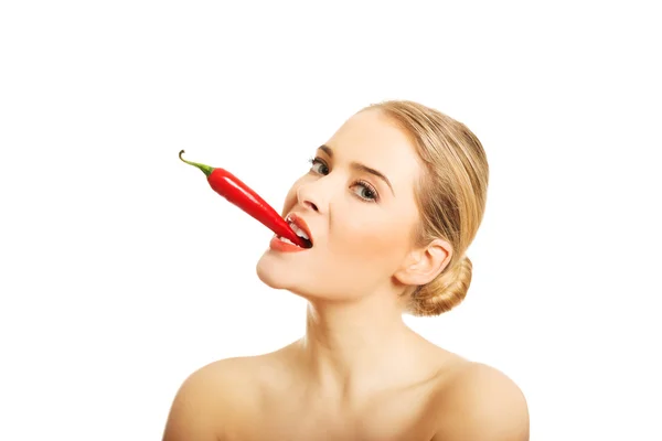 Mujer desnuda sosteniendo chile en su boca — Foto de Stock