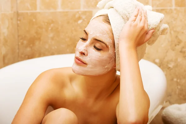 Mujer con crema facial relajante en baño —  Fotos de Stock