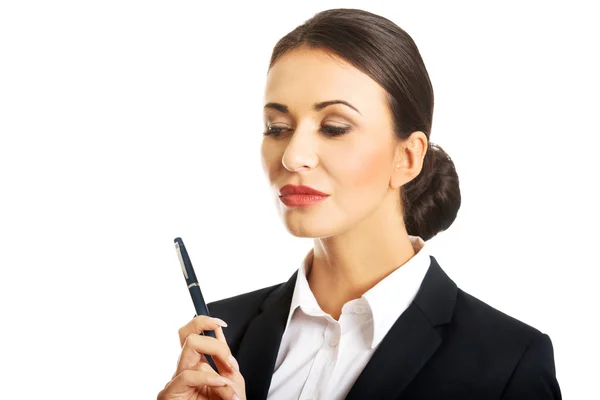 Thoughtful businesswoman holding a pen — Stock Photo, Image