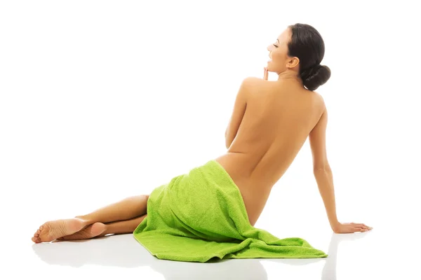 Kvinna sittande insvept i handduk — Stockfoto