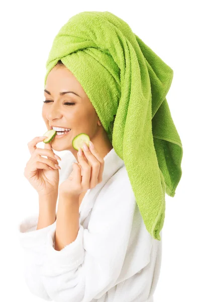 Kvinna i badrock äta gurka — Stockfoto