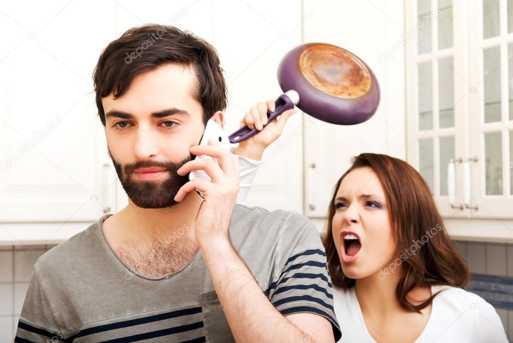 Angry woman hitting man with frying pan.