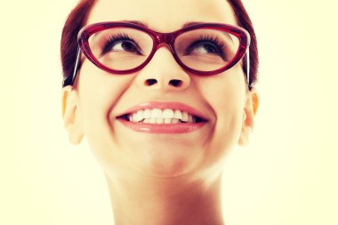 Yukarıya bakıp gülümseyen genç güzel kadın.