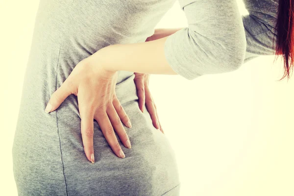 Mujer joven está teniendo dolor de espalda . — Foto de Stock