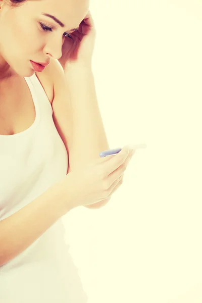 Worried woman holding pregnancy test. — Stock Photo, Image