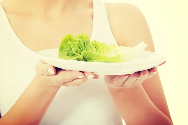 Mujer joven con lechuga en un plato . —  Fotos de Stock